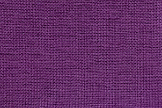 Fondo violeta oscuro de un material textil con un patrón de mimbre, primer plano.