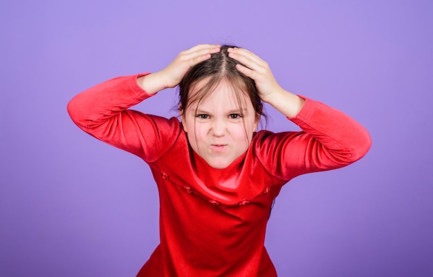 Fondo violeta de la pequeña niña de la cara emocional. No puede detener sus sentimientos. Perdió el control emocional. Expresión emocional de la cara del niño pequeño de la muchacha. Casi loco. Concepto de emociones desatadas. Bebé desesperado.