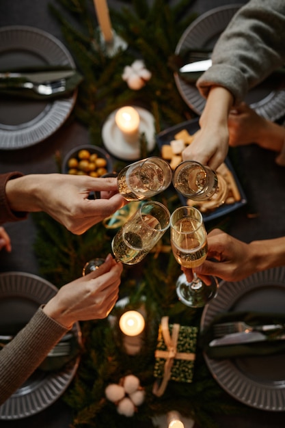 Foto fondo de vista superior de cuatro personas disfrutando de la cena de navidad juntos y brindando con champán gl ...