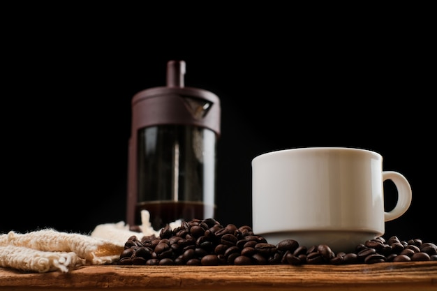 Fondos de café, taza de café y prensa francesa de café en la mesa de madera rústica con espacio de copia