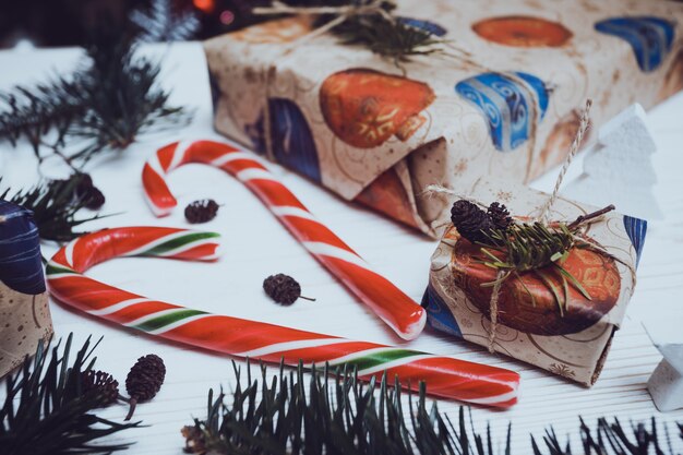 Foto fondos navideños. regalos y caner de caramelo en el fondo de madera.