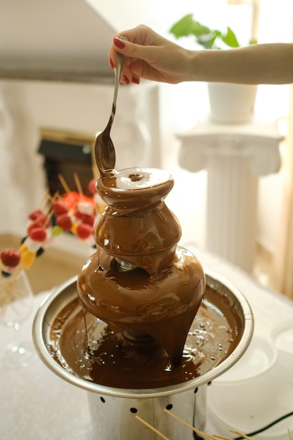 Fondue com fonte de chocolate e doces. tema doce