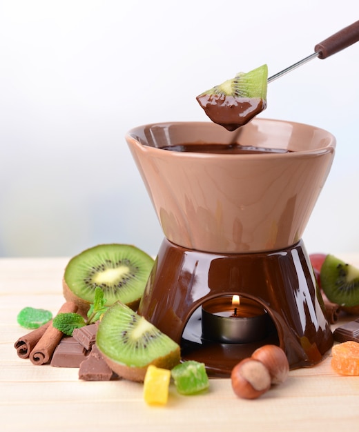 Fondue de chocolate com frutas, mesa de madeira cinza