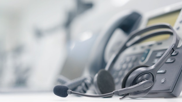 fone de ouvido com aparelhos de telefone na mesa do escritório para atendimento ao cliente