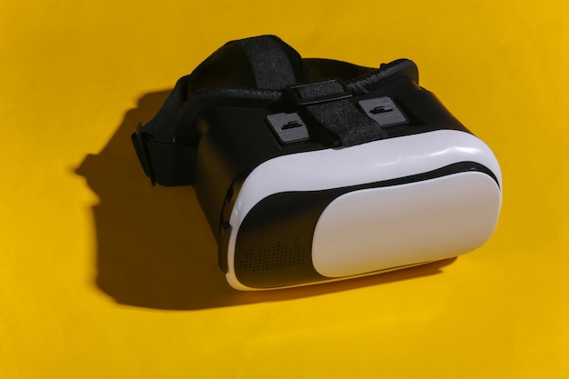 Fone de ouvido de realidade virtual com joystick em fundo amarelo. Gadgets modernos