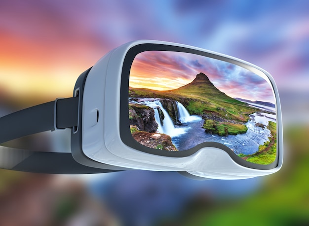 Fone de ouvido de realidade virtual, dupla exposição, o pitoresco pôr do sol sobre paisagens e cachoeiras. Kirkjufell mountain