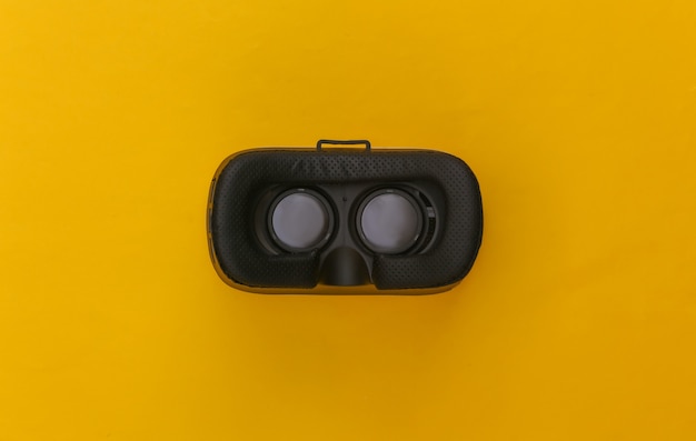 Fone de ouvido de realidade virtual em fundo amarelo. Vista do topo. Esfolar. Minimalismo