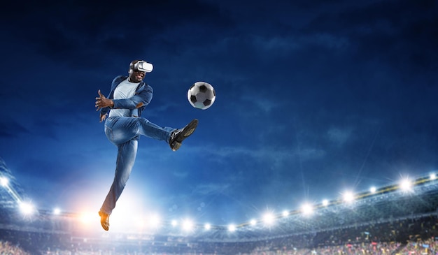 Fone de ouvido de realidade virtual em um homem negro jogando futebol. Mídia mista