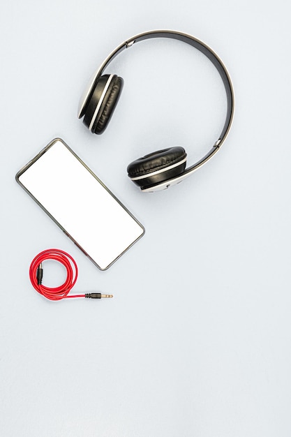 Foto fone de ouvido e um telefone em um fundo branco pronto para ouvir música