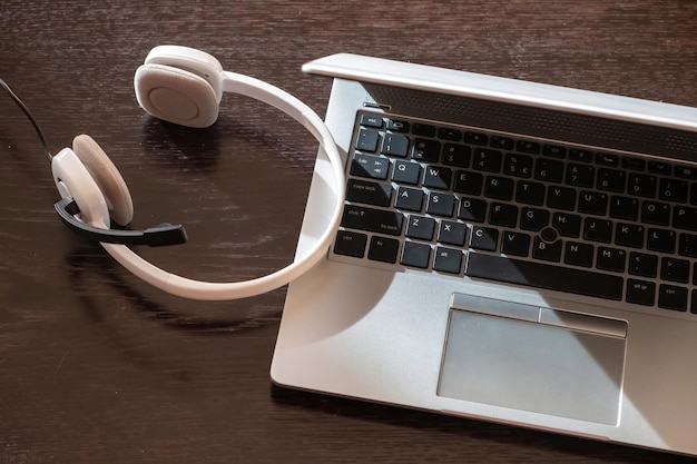 Foto fone de ouvido em uma mesa de madeira de laptop call center escritório em casa suporte ao cliente mesa de ajuda