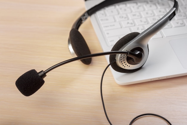 Fone de ouvido no laptop do computador teclado