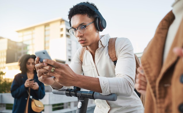 Fones de ouvido de telefone masculino ou scooter elétrico na sustentabilidade da cidade comutar ecologicamente correto e transporte de pegada de carbono Estudantes de viagem Escooter ou amigos da moda em tecnologia de mídia social móvel