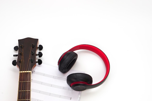 Fones de ouvido de violão e notas musicais em um fundo branco Conceito de amor e música