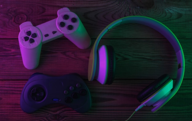Fones de ouvido estéreo com gamepads retrô em luz neon roxa e verde