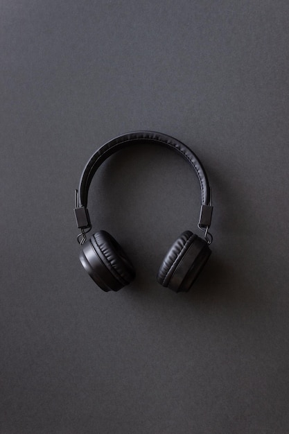 Fones de ouvido pretos sobre um fundo preto conceito minimalista Mockup Music