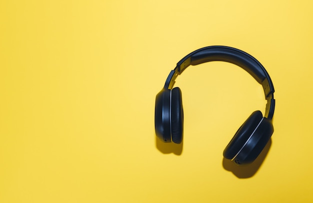 fones de ouvido sem fio pretos isolados em um fundo amarelo