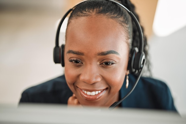 Fones de ouvido telemarketing e mulher negra com um sorriso leitura on-line e conexão com a internet com ajuda pessoa feminina crm e consultor feliz com vendas de telecomunicações serviço ao cliente e suporte técnico