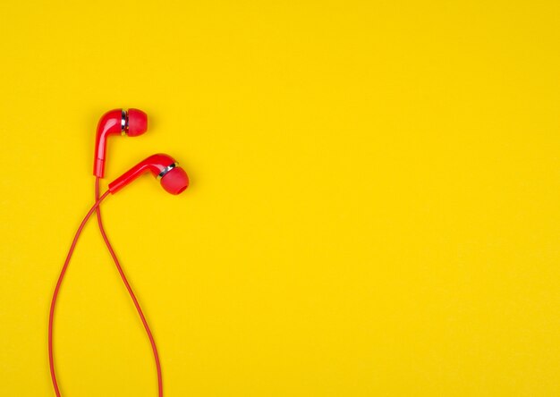 Fones de ouvido vermelho sobre um fundo amarelo brilhante