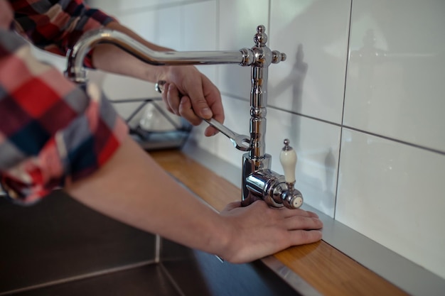 Fontanero reparando un grifo en la cocina