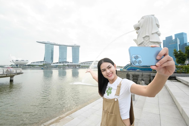 Fonte Merlion em frente à Baía de Marina com uma jovem turista asiática