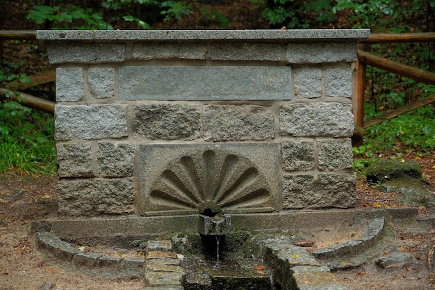 Fonte subterrânea de água limpa uma fonte de água flui de um edifício de pedra