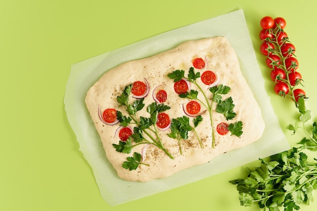 Food art focaccia pizza pan plano con verduras color verde brillante como telón de fondo