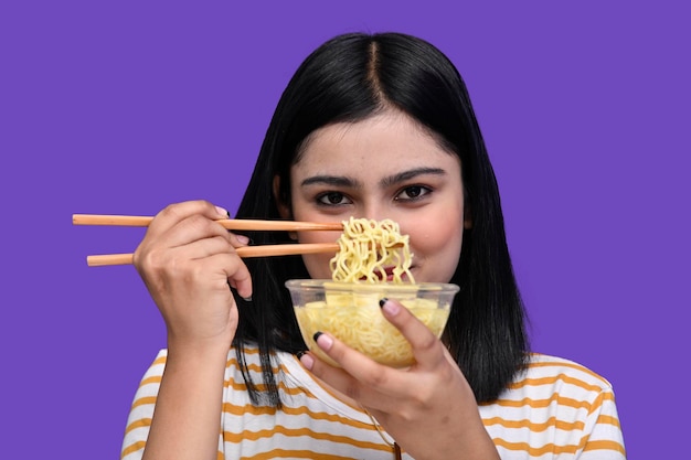 Foodie girl sorrindo e segurando uma tigela de macarrão modelo indiano do paquistanês