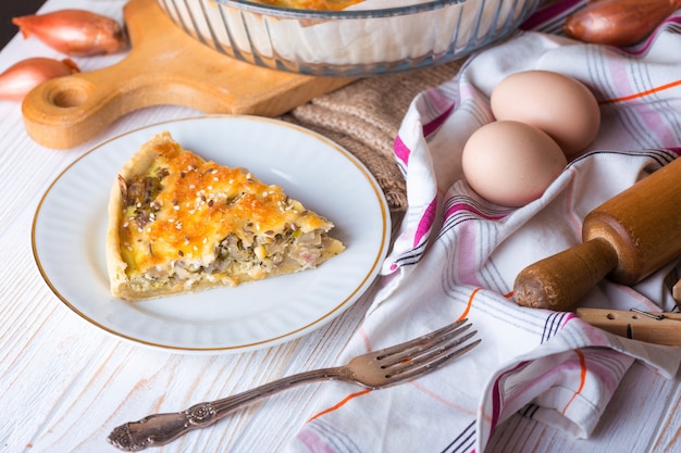 Foodphoto - pastel de cebolla en un plato, cerca de un tenedor, huevos, cebolla