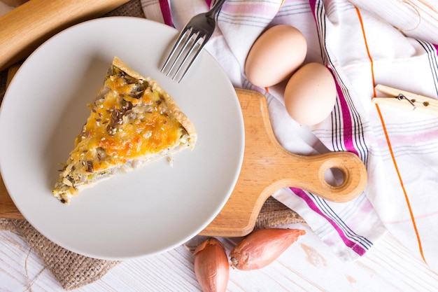 Foodphoto - pastel de cebolla en un plato, cerca de un tenedor, huevos, cebolla