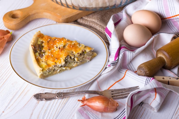 Foodphoto - pastel de cebolla en un plato, cerca de un tenedor, huevos, cebolla