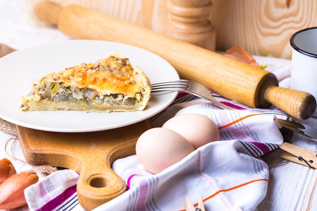 Foodphoto - torta de cebola em um prato, perto de um garfo, ovos, cebola