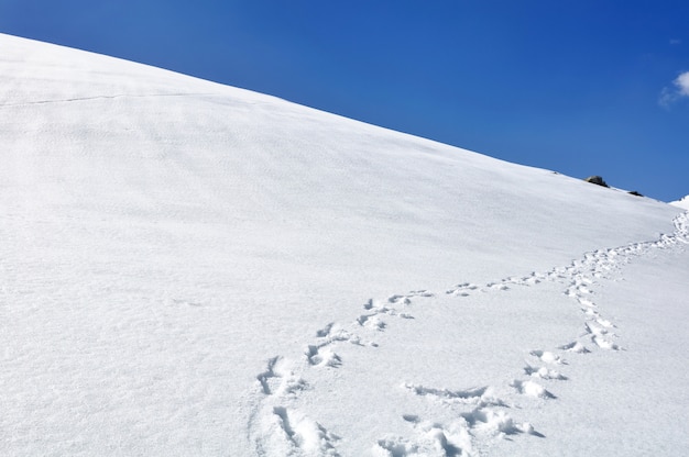 Footsprint na colina coberta de neve