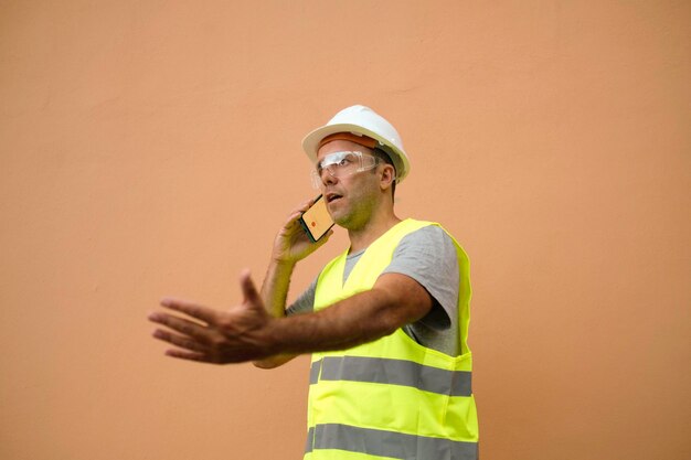 Foreman fala ao telefone enquanto gesticula com as mãos.