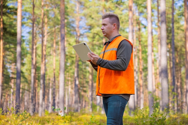 Forester con tablet PC en el bosque