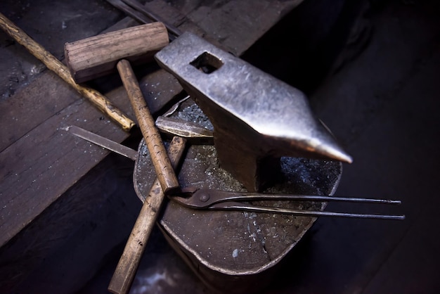 Forja de ferramentas de trabalho consistindo na bigorna, martelo e pinças na oficina tradicional do ferreiro