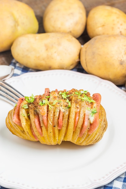 Foto fork ao lado de uma batata saboroso com presunto