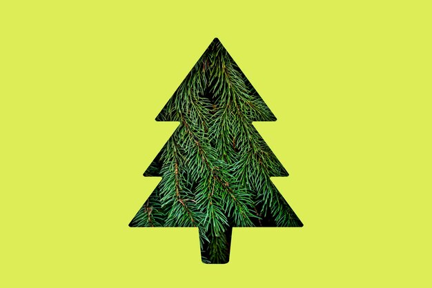 Una forma de árbol de navidad cortada en la superficie colorida concepto de vacaciones creativas