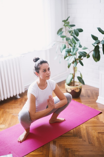 Forma atractiva deportiva mujer de mediana edad haciendo posturas de yoga sentado en el suelo