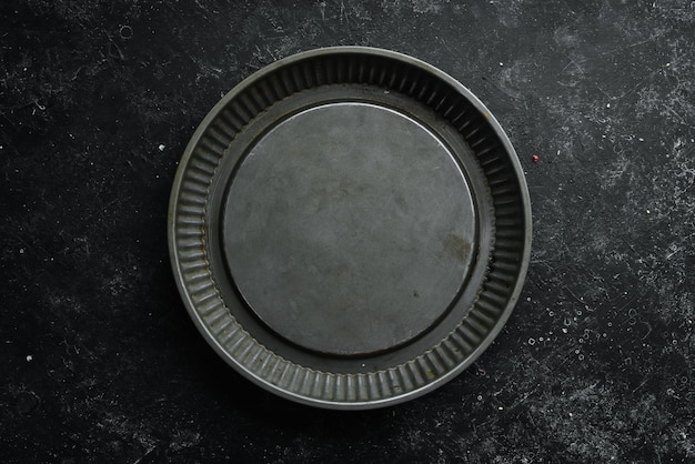 Forma de cocina de metal para hornear alimentos Sobre un fondo negro Vista superior Espacio de copia libre