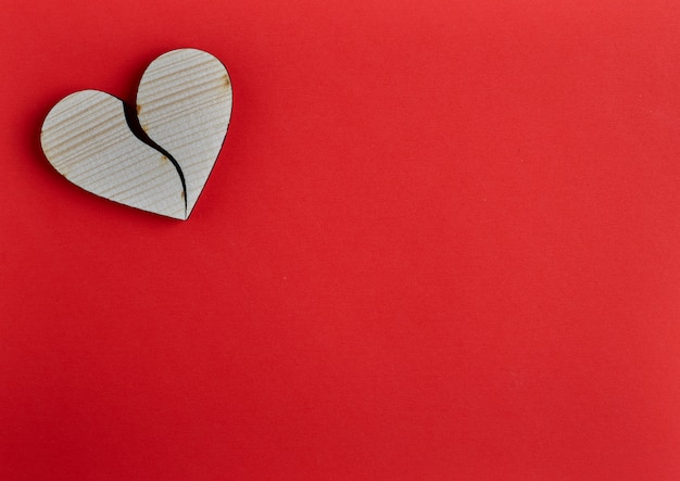 Forma de corazón de madera sobre papel rojo