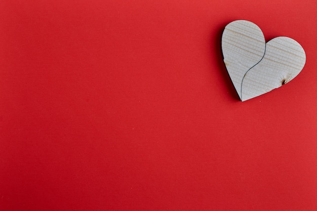 Forma de corazón de madera sobre papel rojo