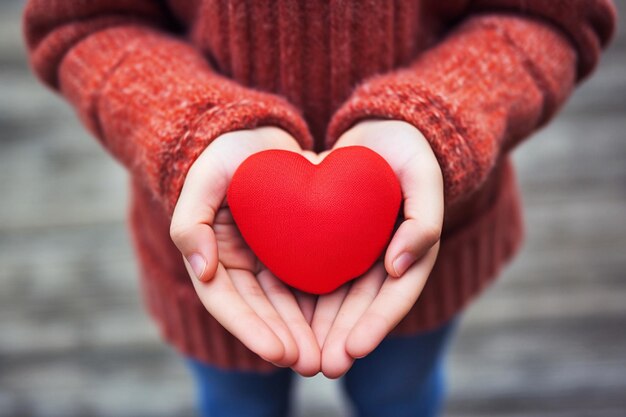 forma de corazón en las manos de los niños para el día de San Valentín el día de san Valentín corazón en manos fondo