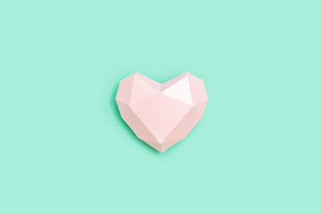 Forma de corazón de papel poligonal rosa sobre papel de color menta Concepto de amor Estilo minimalista de color pastel