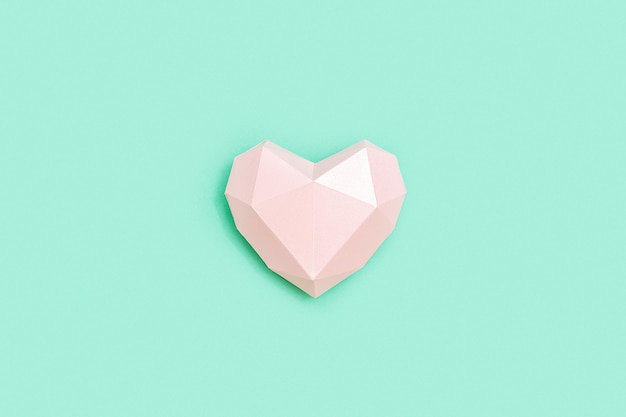 Forma de corazón de papel poligonal rosa sobre papel de color menta Concepto de amor Estilo minimalista de color pastel