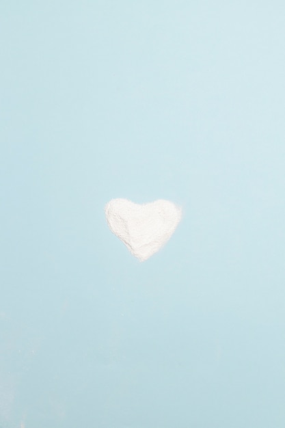 Foto en forma de corazón en polvo de harina o proteína en el cuadro azul. día internacional contra el uso indebido de drogas