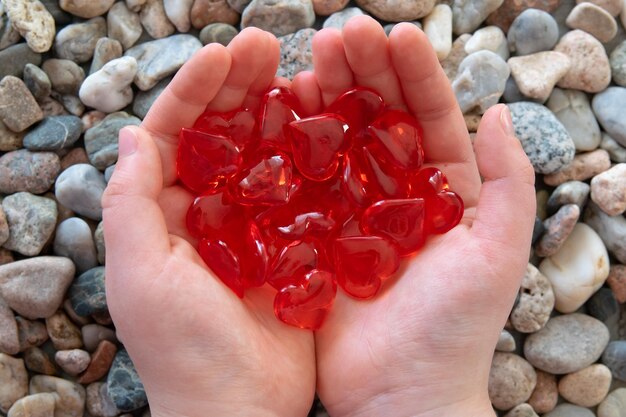 Forma de corazones de vidrio rojo en el fondo de la naturaleza de piedra