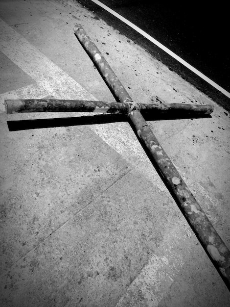 Foto forma de cruz de madeira caindo na calçada