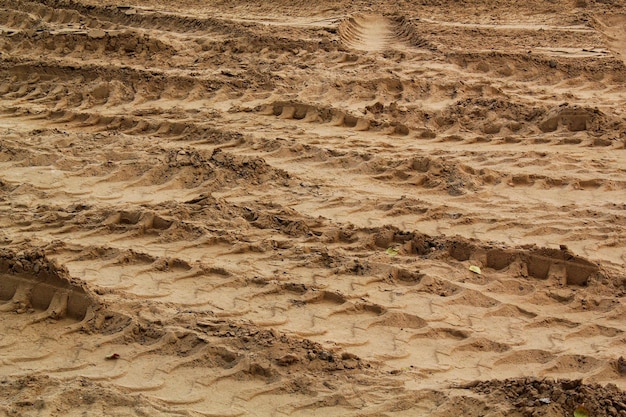 Forma de linhas de marca de trilha de pneu no fundo de areia seca. Marca de pneu de trilha de máquinas pesadas. Veículo