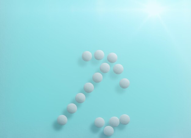 Forma de seta feita de pílulas médicas em bacground azul