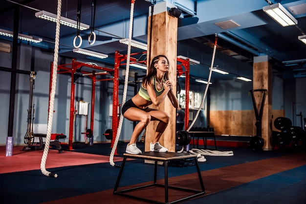 Forma joven cuadro saltando en un estilo crossfit